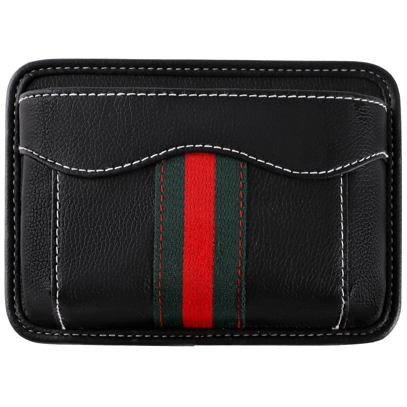 Black nylon car organizer box bag on an air vent, storing a phone and cards in a vehicle interior.