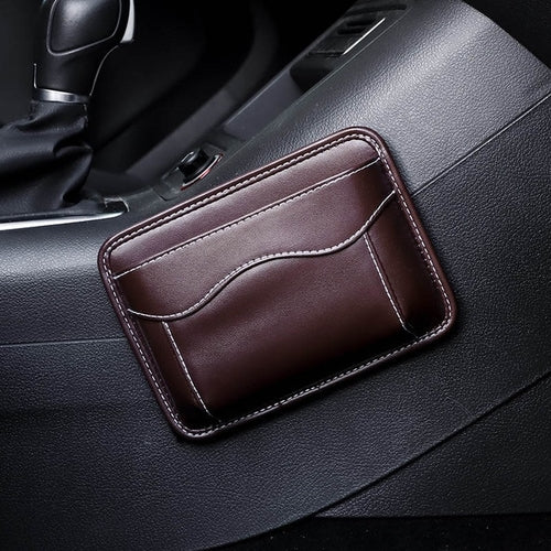 Black nylon car organizer box bag on an air vent, storing a phone and cards in a vehicle interior.